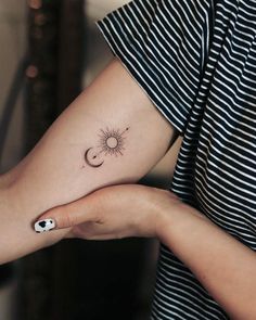 a woman with a sun and moon tattoo on her arm