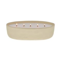 a white bowl with five candles in it