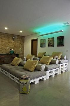 a living room with couches made out of pallets and lights on the ceiling