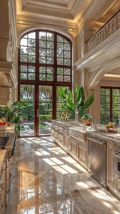 a large kitchen with marble counter tops and stainless steel appliances in front of an arched window