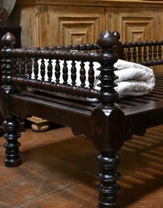 an old wooden bench with white towels on it