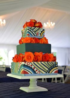 a multi - tiered cake with orange flowers on top