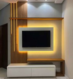 the television is mounted on the wall in the living room with modern furniture and lighting