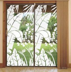 an open window with white flowers and leaves drawn on it in front of a tiled floor