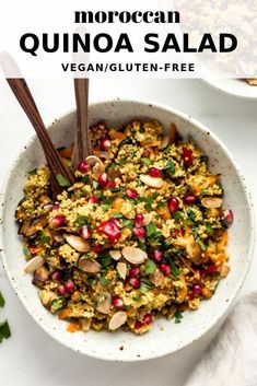 a white bowl filled with quinoa salad and topped with pomegranate