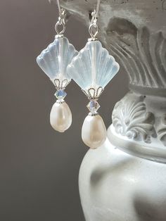 I created these 1920s inspired earrings with my favorite jewelry components - Czech glass beads, Swarovski crystals, and Swarovski pearls. This is a classic Art Deco design; perfect for a 1920s style wedding or party. The Czech beads are shaped like fans; one of the most popular design motifs during the Roaring Twenties. Elegant Swarovski crystals and pearls complete the design. One side of the clear matte Czech beads has an Aurora Borealis coating which gives a subtle shimmer of blue. These ear 1920s Style Wedding, Art Deco Jewelry 1920s, Gatsby Jewelry, Bride Vintage, Earrings Bride, Great Gatsby Wedding, Design Motifs, Pearl Jewels, 1920s Style