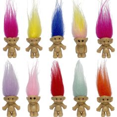 small toy trolls with different colored hair on them