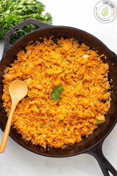 a skillet filled with rice and garnished with cilantro on the side