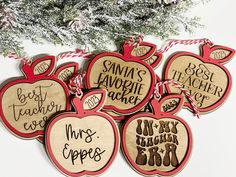 six wooden apple ornaments hanging from a christmas tree