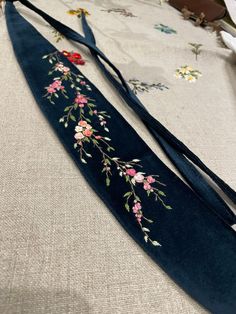 Dark blue velvet belt with Sakura hand-embroidered with moulin thread.   This belt will be great to wear on any celebratory event and will compliment any outfit (casual, formal, etc.).  As a handmade accessories designer, finding my new passion was challenging, interesting, and exciting.  Every moment of this journey of learning, making, and achieving is an act of pleasure. Seeing people appreciate what you do and receiving support and positive feedback kept me going. With every creation, every Embroidery Belt, Dark Blue Velvet, Velvet Belt, Embroidered Bracelet, Embroidered Belt, Embroidered Velvet, Sakura Flower, Embroidery Bags, Embroidery On Clothes