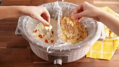 two hands grabbing food out of a plastic container