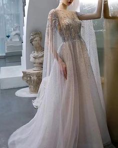 White Embellished Dress With Cape Sleeves, Elegant Floor-length Kaftan For Banquet, Elegant Floor-length Kaftan For Banquets, Elegant Long Sleeve Kaftan For Banquets, White Embellished Long Dresses, White Long Train Dress For Banquet, Evening Dresses With Sweep Train And Cape Sleeves, Evening Dress With Cape, Tulle Applique