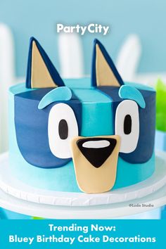 a blue birthday cake decorated with an angry bird face and the words party city trending now