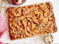 an apple pie on a cutting board next to a bowl of oatmeal