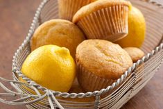 a wire basket filled with muffins and lemons