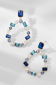 Elevate your look with these statement-making earrings! Showcasing an intricate mix of unique, mixed-cut clear CZ and blue stones, blending luxury and style for a must-have earring set. Blue Sparkling Dangle Earrings, Blue Cubic Zirconia Crystal Earrings, Blue Cubic Zirconia Earrings With Sparkling Stones, Blue Dangle Earrings With Sparkling Stones, Blue Cubic Zirconia Drop Earrings, Blue Crystal Earrings With Sparkling Stones For Party, Blue Crystal Jewelry With Gemstone Accents, Glamorous Blue Drop Earrings, Blue Jeweled Crystal Earrings