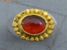 "One of a king signet ring. Deep red Garnet wrapped with 24k solid gold surrounded by handcraft 24k gold punched dots. The sterling silver ring has matte rustic finish. Garnet ring size - 7. Top ring dimensions - 0.47'/0.6\" (12/15mm). The ring will be packed in a gift box ready to be given as a gift, and will be shipped with express mail service that usually takes 2-8 days to arrive. ▶ View my other rings here: https://www.etsy.com/shop/Omiya?section_id=7425981 Please contact me with any questi Gold And Silver Ring, Signet Rings, Top Rings, Gold And Silver Rings, Garnet Ring, A King, Garnet Rings, Red Garnet, Jewelry Lover