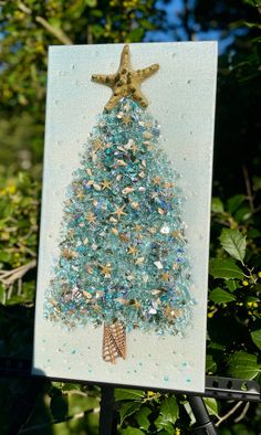 a card with a christmas tree made out of sea glass and gold starfish on it