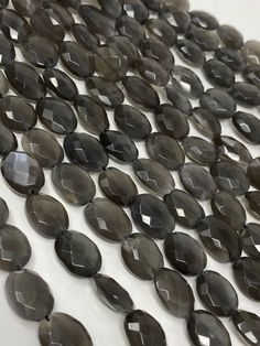 black glass beads are arranged on a white surface