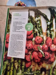 an open book with tomatoes and asparagus on it