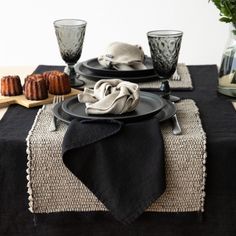 a table with black plates and silverware on it