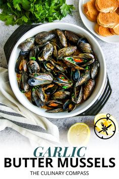 garlic butter mussels in a white bowl with lemon wedges and parsley