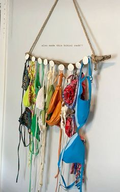 there are many bras hanging on the wall with strings attached to it and two hooks holding them