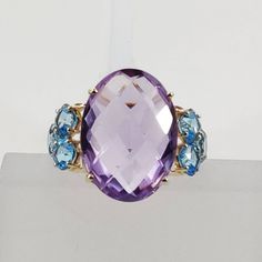 This stunning ring is set in 14k Solid Yellow Gold with Natural Purple Amethyst and Swiss Blue Topaz with utmost precision. It is an unique statement gemstone ring for nearly every occasion and is completely hassle-free jewelry. ITEM DETAILS * GEM: Purple Amethyst * GEM SIZE: 13X18 mm * GEM SHAPE: Oval Briolette * GEM: Swiss Blue Topaz * GEM SIZE: 4 mm (6pcs) * GEM SHAPE: Cushion * Total GEM WEIGHT: 13.00 carats * Gold Purity: 14KT * Gold Weight: 1.77 gram * Total Weight of the Ring: 4.37 gram T Multi-stone Purple Gemstone Ring, Purple Multi-stone Gemstone Rings, Luxury Blue Amethyst Gemstone Ring, Fine Jewelry Oval Multi-stone Amethyst Ring, 14k Gold Multi-stone Purple Amethyst Ring, Purple Tanzanite Multi-stone Rings, Blue Oval Amethyst Jewelry, Formal Purple Topaz Gemstone Ring, Blue Amethyst Multi-stone Jewelry