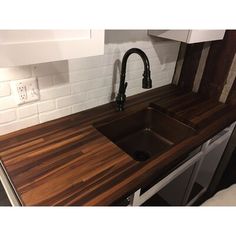 a kitchen counter with a sink and faucet