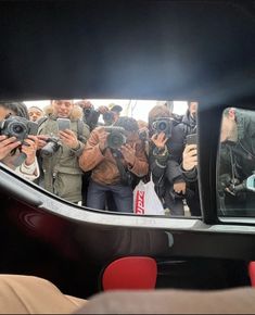 a group of people taking pictures in the back of a car