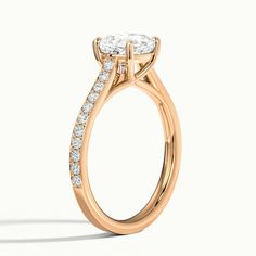 a rose gold engagement ring with an oval cut diamond in the center and side stones