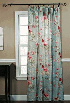 a curtain with flowers on it in front of a window sill and white trim