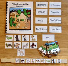 a wooden table topped with cards and pictures next to a book about desert animal life