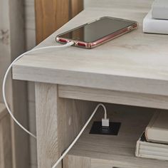 an electronic device is plugged in to a charging station on a table with books