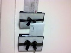 two black and white boxes with bows hanging on the wall in front of a door