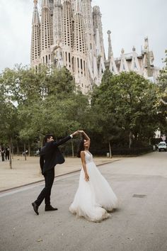 a bride and groom dancing in front of the saguada church