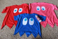 three children's t - shirts with eyes on them are laying on the floor