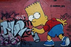 the simpsons character spray painting on a brick wall