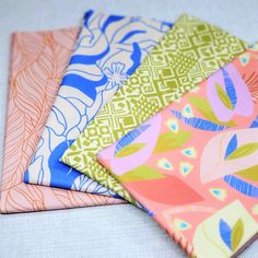 four different colored papers with designs on them