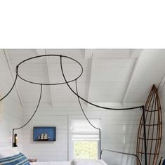 a bedroom with white walls and wood flooring is shown in this image, there are two surfboards hanging from the ceiling