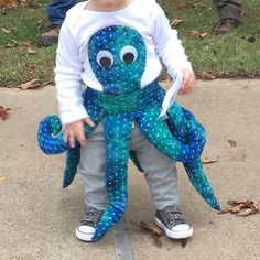 a young boy holding an octopus stuffed animal