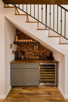 a wine rack under the stairs in a home bar with built - in wine bottles