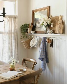 a wooden table topped with dishes and utensils next to a wall mounted potted plant