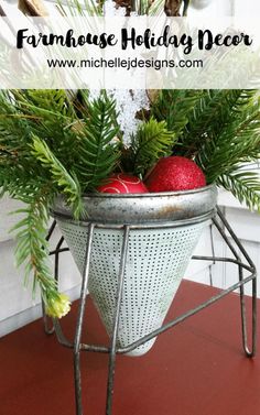 a metal basket filled with christmas decorations on top of a wooden table next to a window