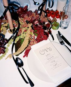 the table is set with an elegant menu and utensils for guests to eat