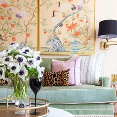 a living room filled with lots of furniture and flowers in vases on the coffee table