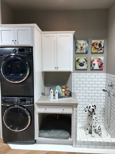 a washer and dryer in a small room with white tile walls on the wall