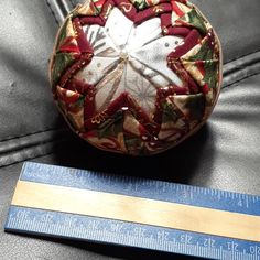 a christmas ornament sitting on top of a couch next to a measuring ruler