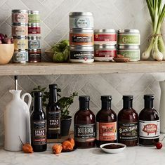 an assortment of condiments are displayed on a kitchen counter with jars and containers