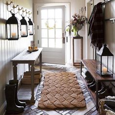 an entryway with lots of coat racks on the wall and a rug on the floor